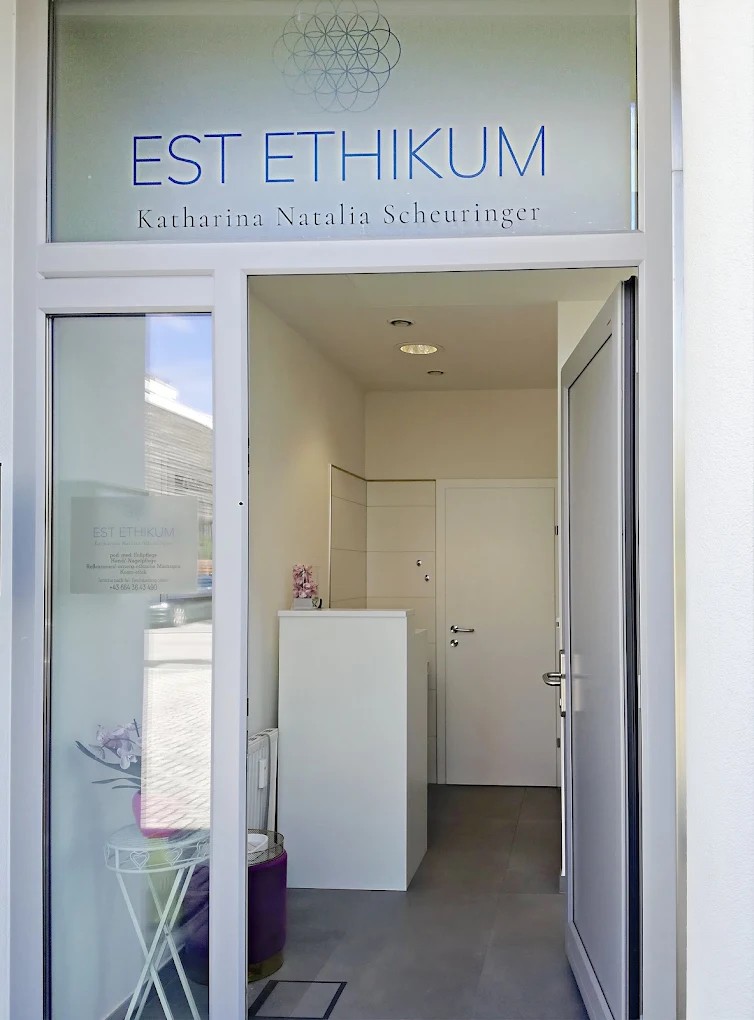 Eingang des Studios EST ETHIKUM in der Eduard-Macheiner-Stra&szlig;e 3 in Salzburg &mdash; Blick durch die ge&ouml;ffnete Glast&uuml;r in den Empfangsbereich